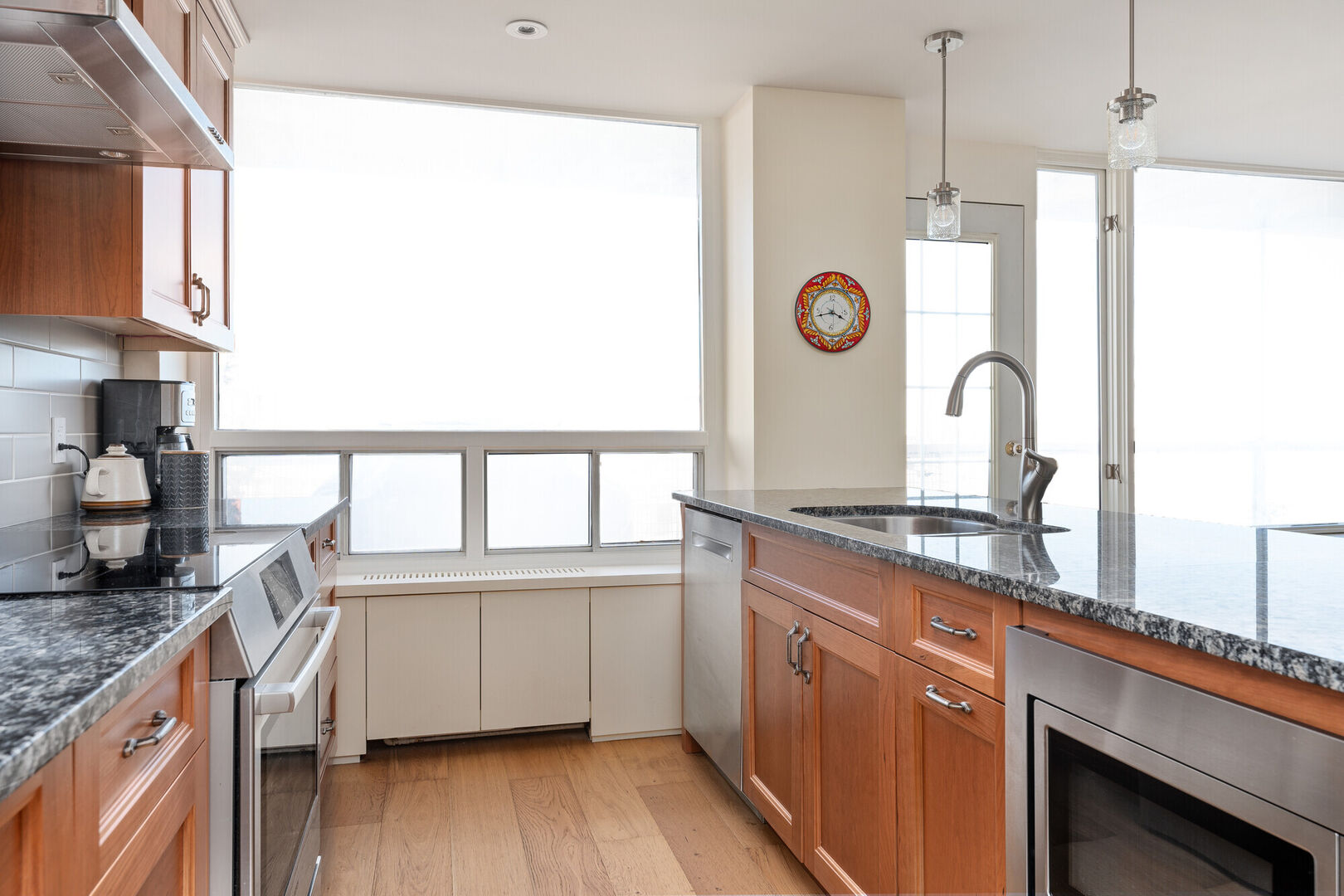 A modern light bright kitchen with orange wood cabinets Calgary southwest interior design